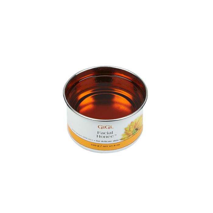 Angled top view of an open can of GiGi Facial Honee Soft Wax with melted translucent rich golden brown wax inside 