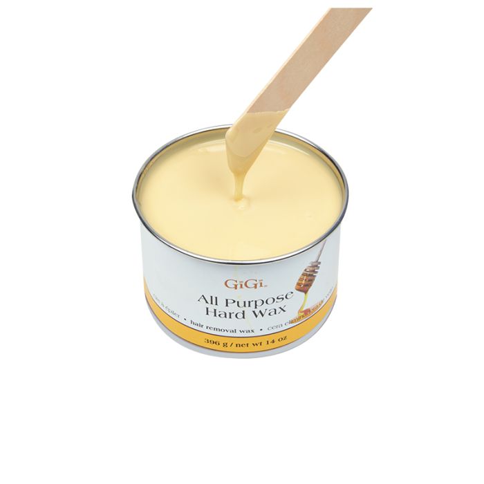 Applicator stick being drawn out of melted GiGi All Purpose Hard Wax in its can featuring its creamy white color & texture